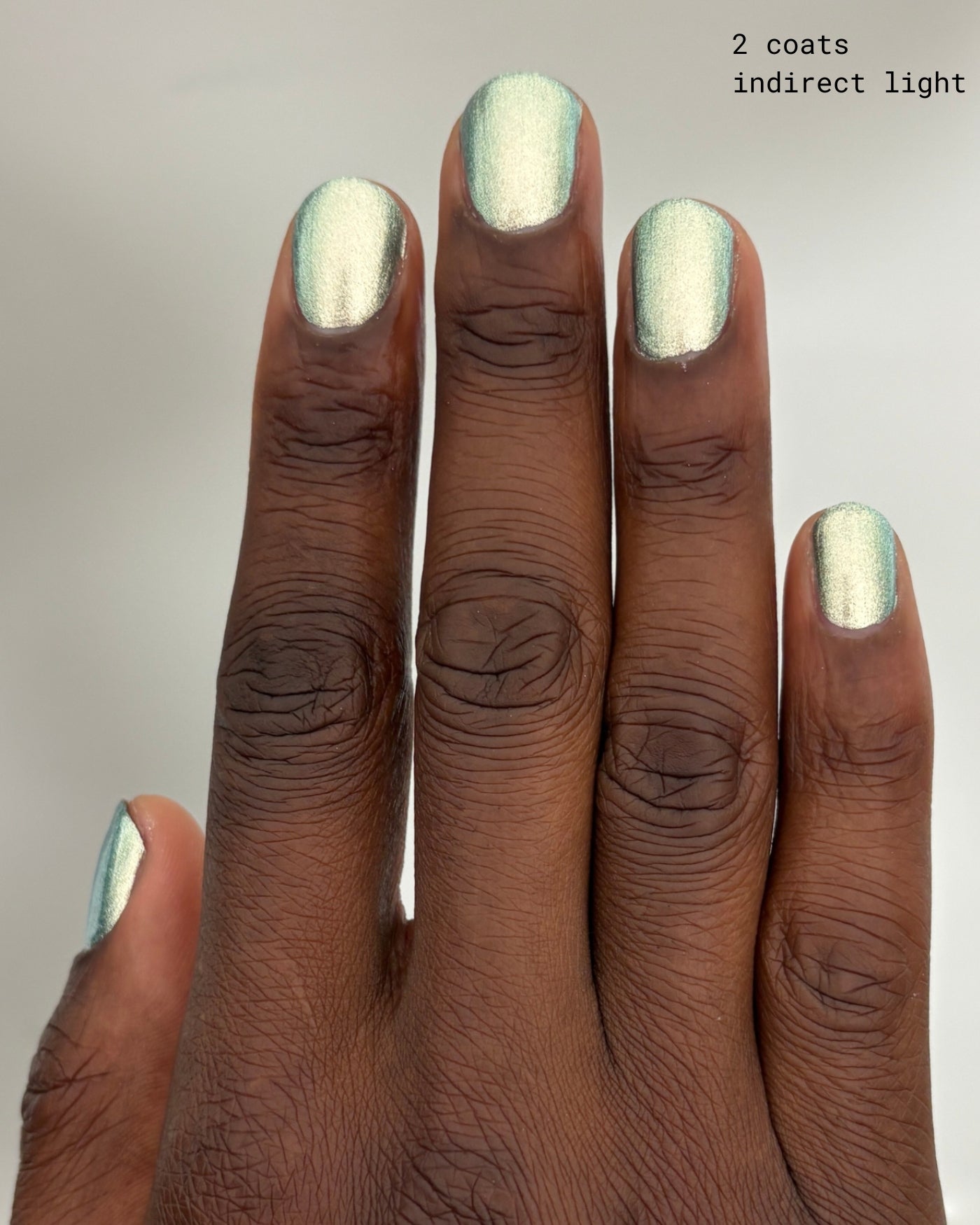 Shimmering metallic green Atomica nail polish in two coats